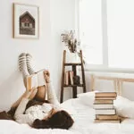 young-woman-lying-bed-with-book (1)